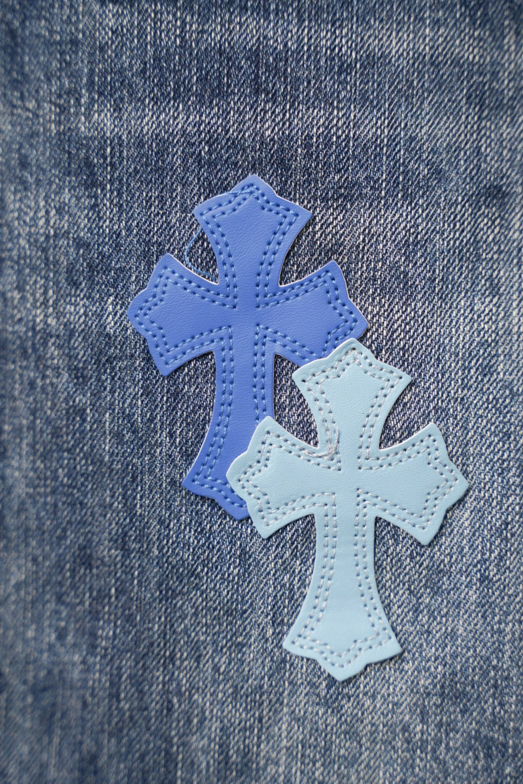 Close-up of blue cross patches on denim fabric