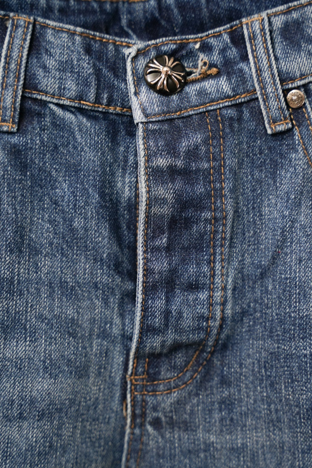 Denim pants waistband and button area with decorative metal-stitch detail