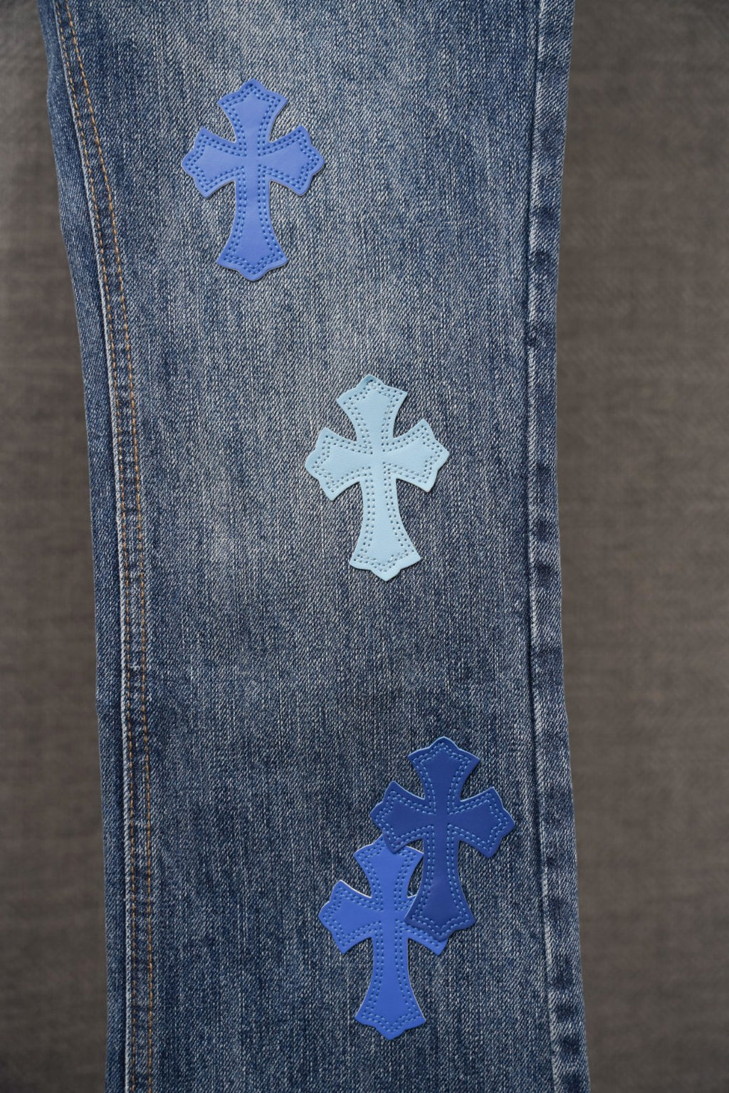 Chrome denim pants with blue cross patches along side panel