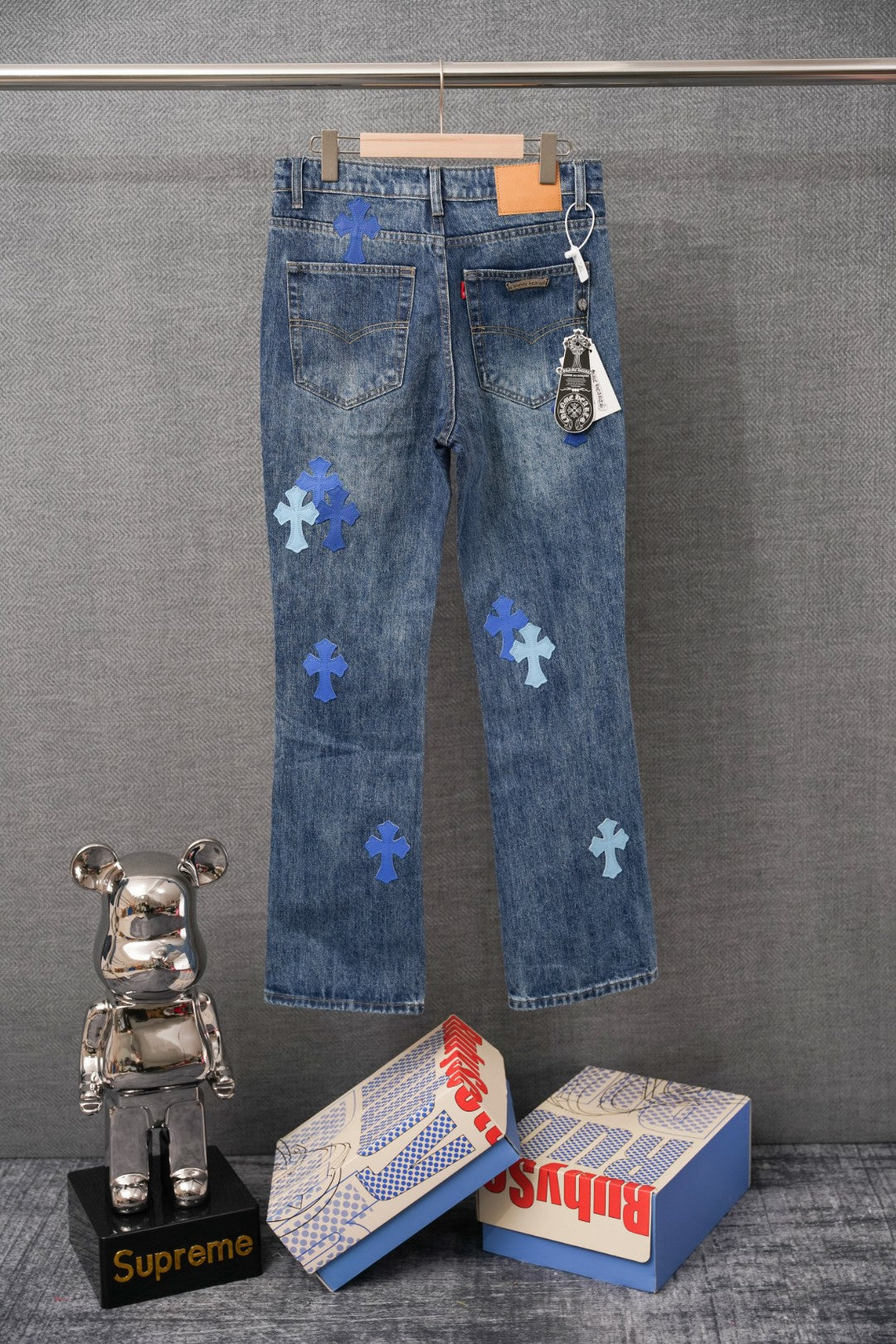 Denim pants with blue cross patches, back view with belt loops and pockets