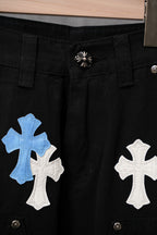 Black pants close-up with large blue and white cross patches on front pocket area.