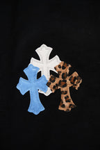 Black pants close-up of blue and white cross appliques with leopard print cross patch