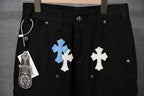 Black pants close-up of fly and belt loop with blue and white cross appliques
