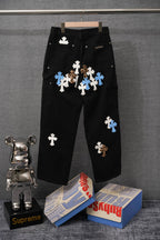 Black pants with scattered blue and white cross applique patches and side pocket buttons