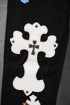 Black pants with large white cross applique and bead-like floral center