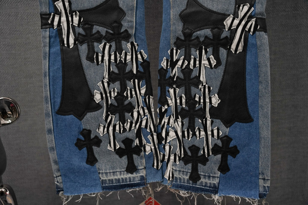 Light-wash denim jeans with dense black cross and striped appliqué cluster