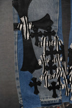 Light-wash denim jeans with layered black and white appliqué graphics on leg