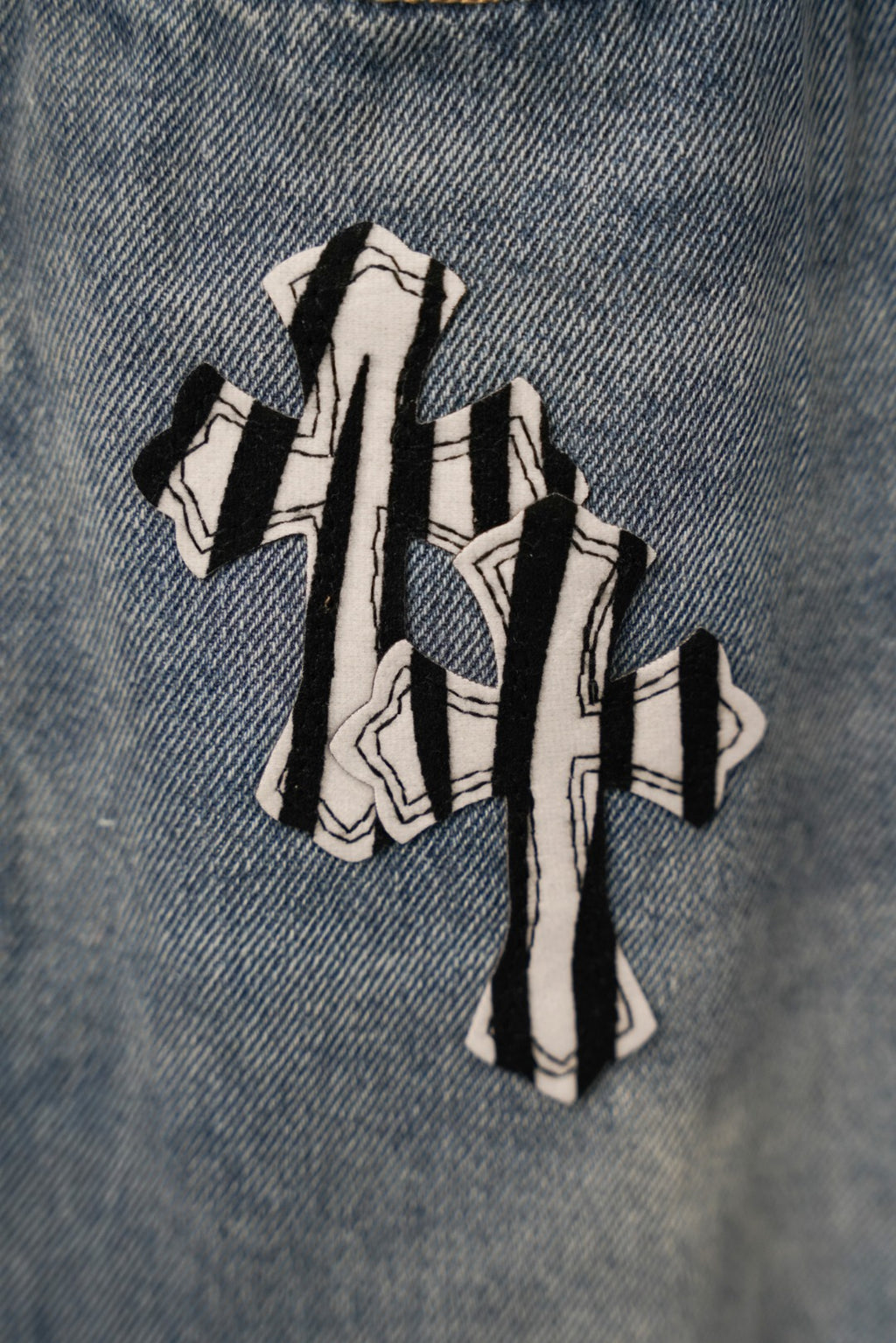 Light blue denim pants with oversized striped graphic print on front leg