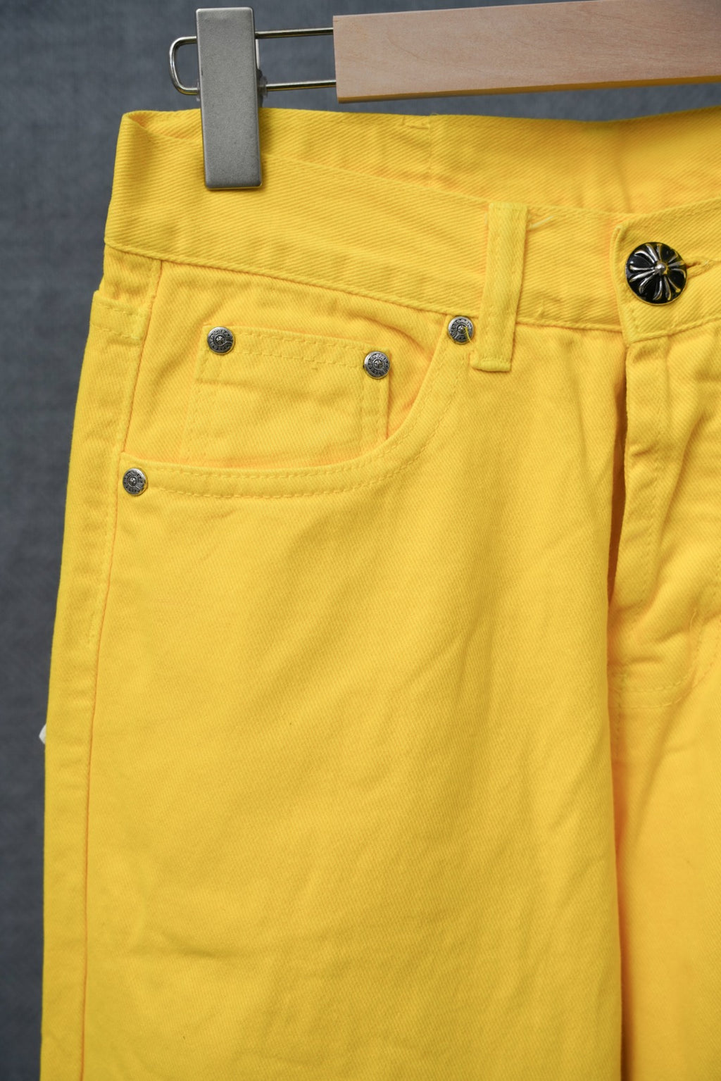Chrome pants in bright yellow with five-pocket styling and metallic rivet details.