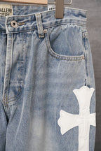 Light blue denim pants with front pockets and white cross applique