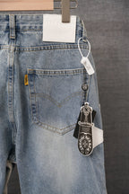 Light blue denim pants with front pocket, waist tag, and keychain charm