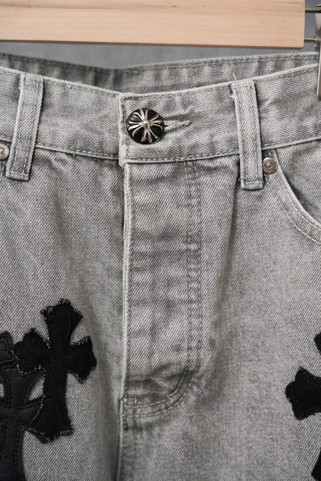 Light-wash denim pants close-up of button waist and belt loops