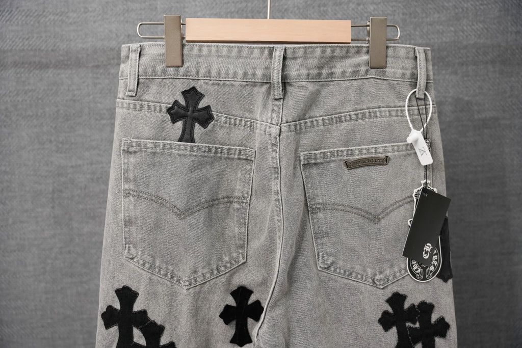 Light-wash denim pants back view with black cross appliques and patch pockets