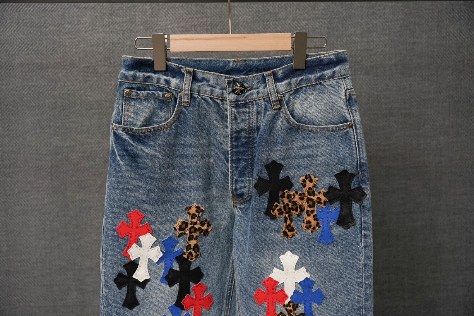 Light blue denim pants with cross patches near the front and waistband