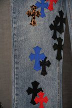 Embroidered cross patches on light blue denim; blue, red, black, and leopard pattern details