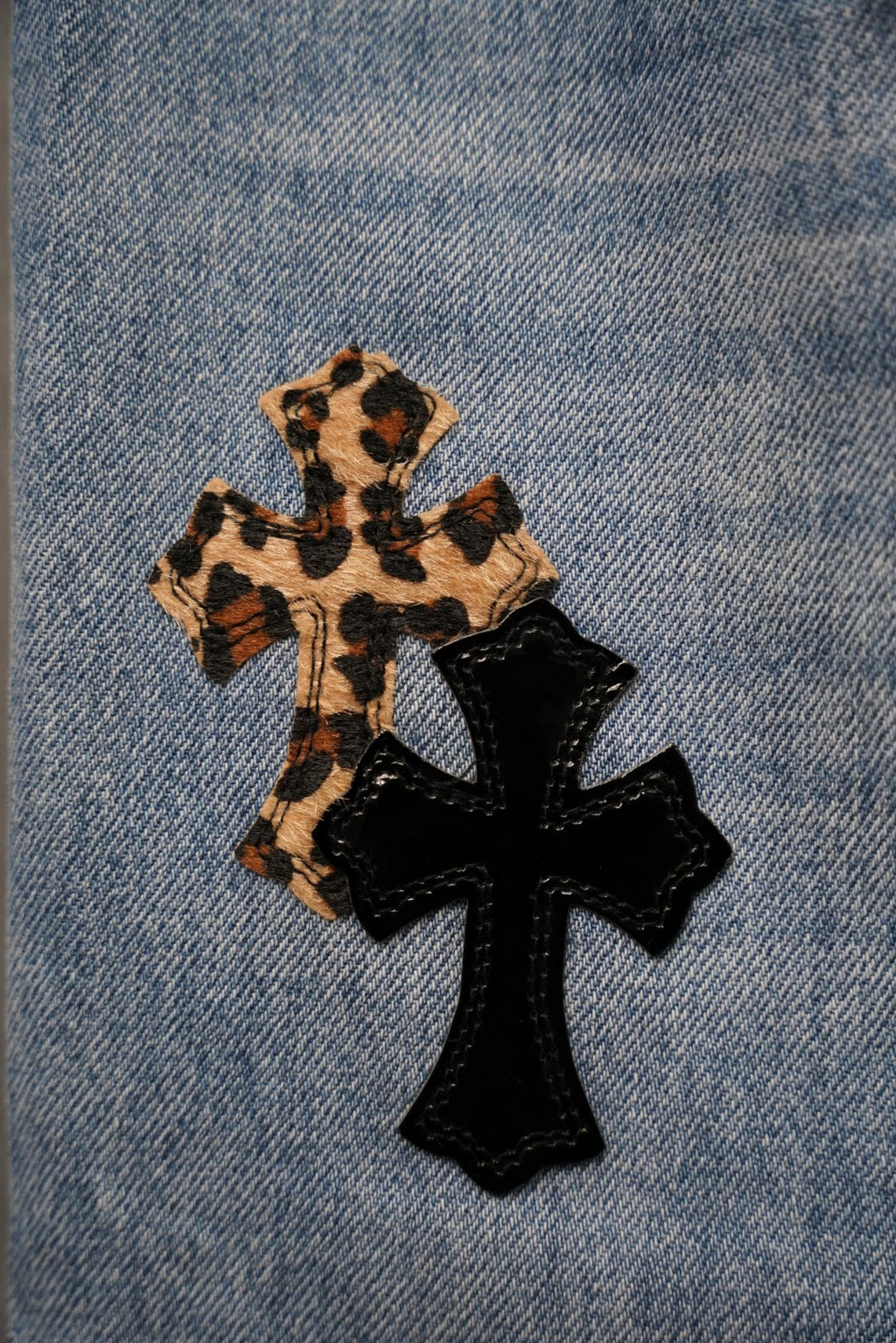 Denim Chrome pants with leopard patch and black cross graphic