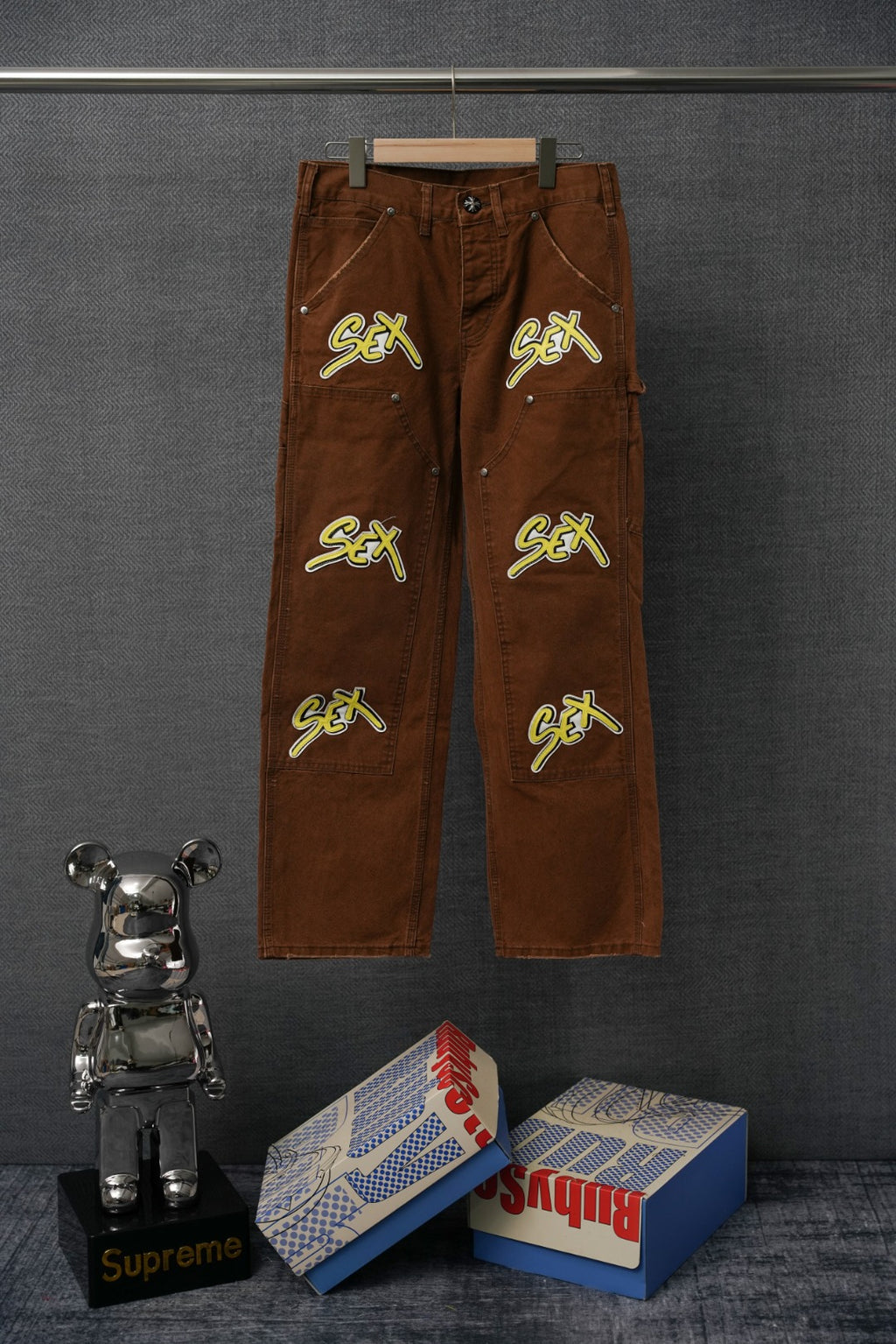 Brown cargo pants with neon “Sex” graphic embroidery on front and back
