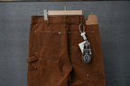 Brown cargo pants with front pockets and hanging tag from waistband
