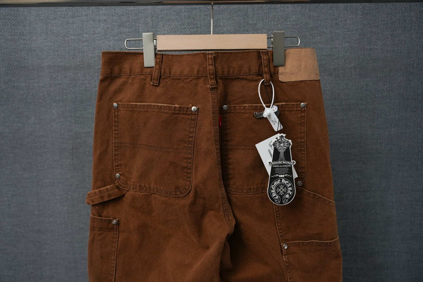 Brown cargo pants back view with keychain tag and front button pockets