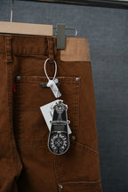 Brown cargo pants with front pockets and metal buttons, hanging tag attached