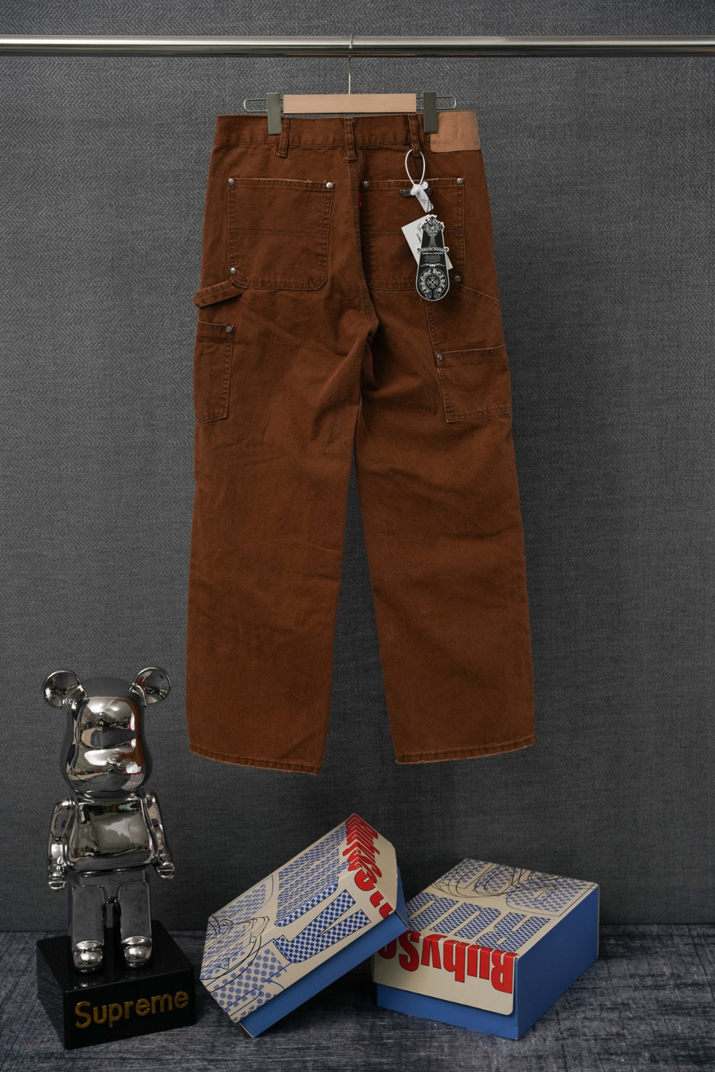 Brown cargo pants with keychain tag and embroidered “S€X” graphic on front
