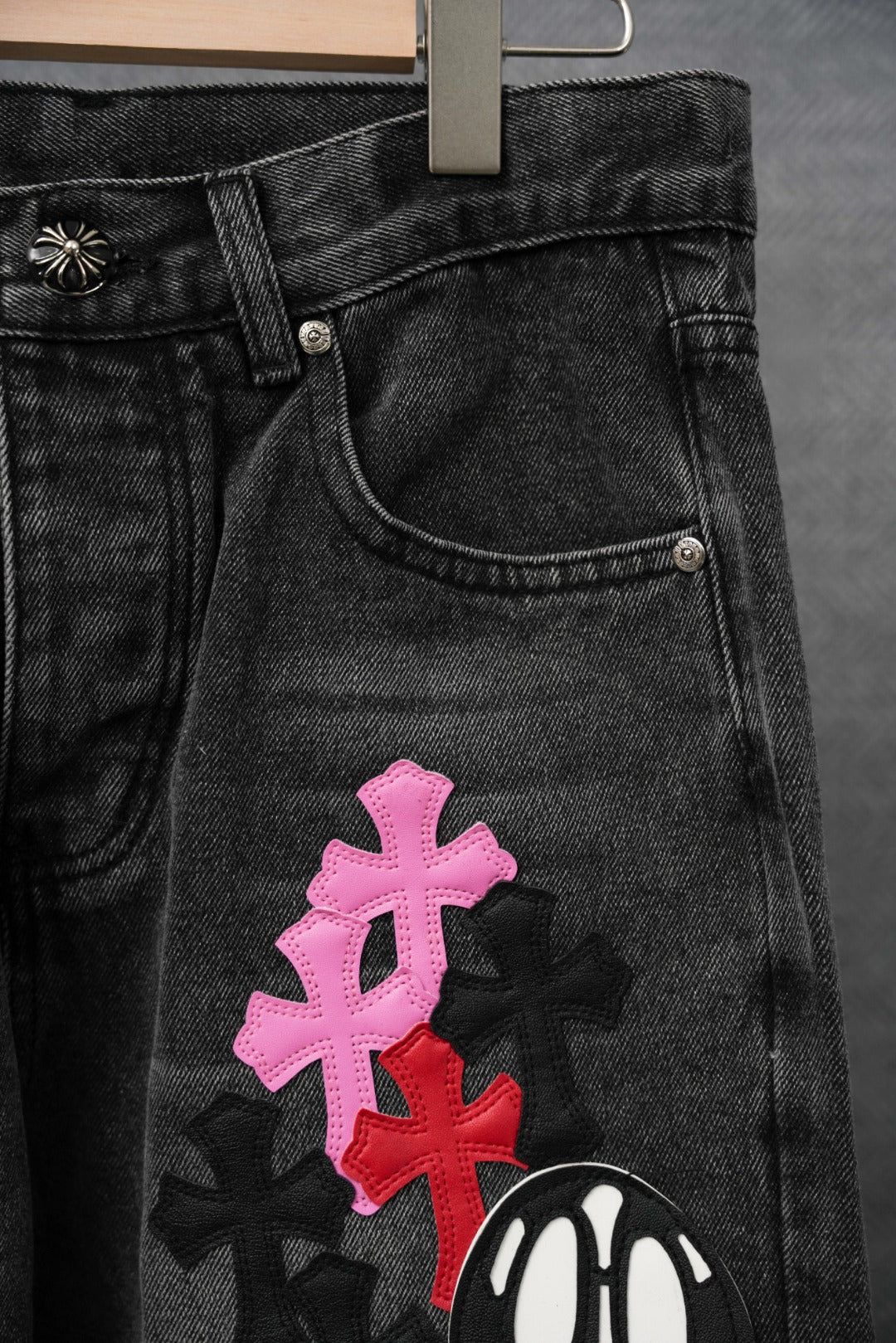 Dark denim pants front pocket with pink and red cross embroidery and skull
