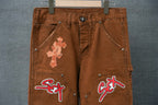 Brown cargo pants front view with cross appliques and “SEX” patch graphics