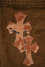 Brown cargo pants close-up of cross applique with stitched detailing