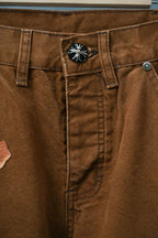 Brown cargo pants close-up of waistband and front buttoned pocket flap