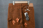 Brown chrome pants with orange cross patches and front pockets