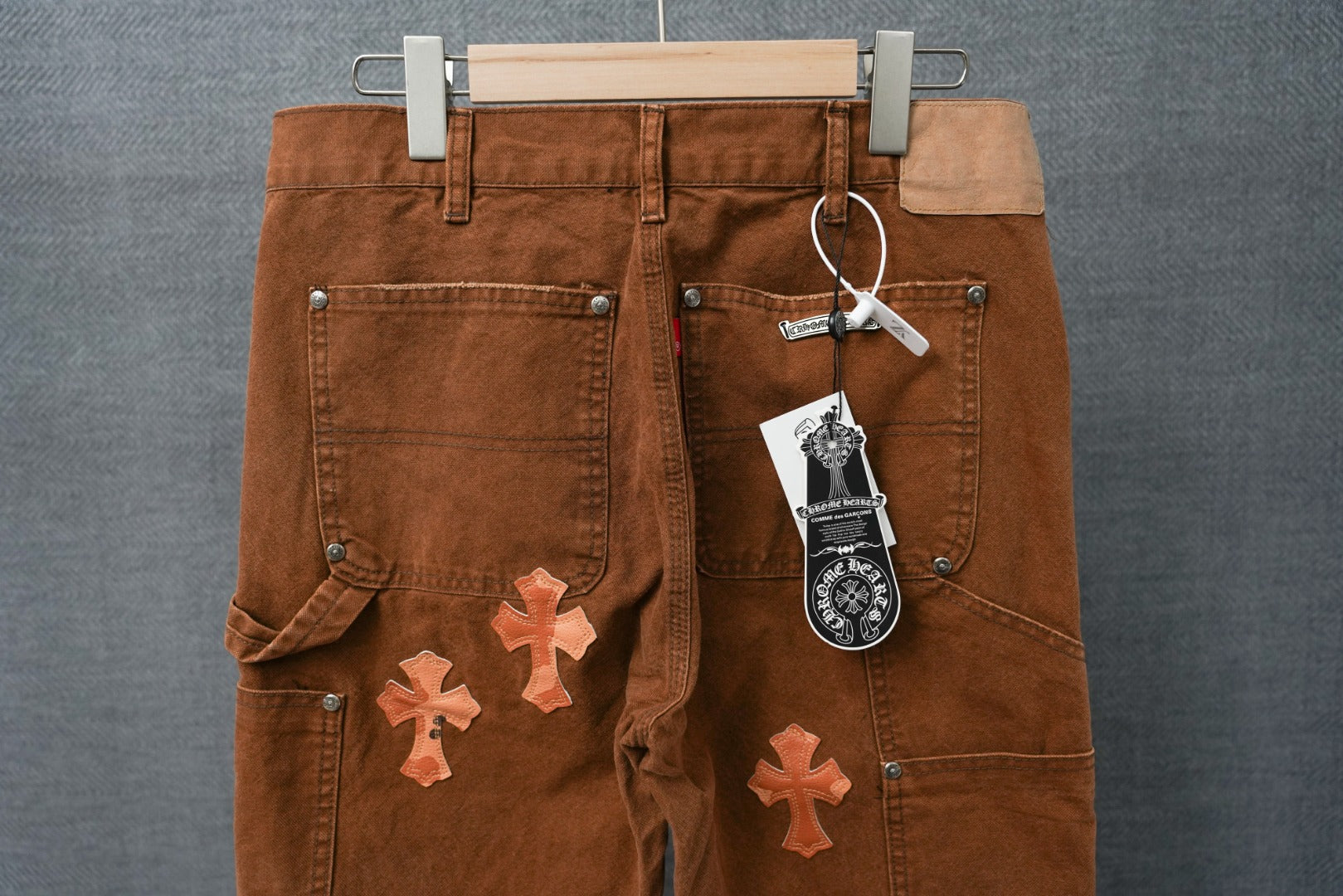 Brown chrome pants with orange cross patches and front pockets