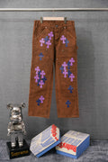 Brown jeans with purple and blue cross patches on front and back