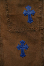 Brown denim pants with blue embroidered cross patches on front panels