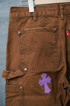 Brown pants with front pocket panel and belt loops; purple cross patch near hip