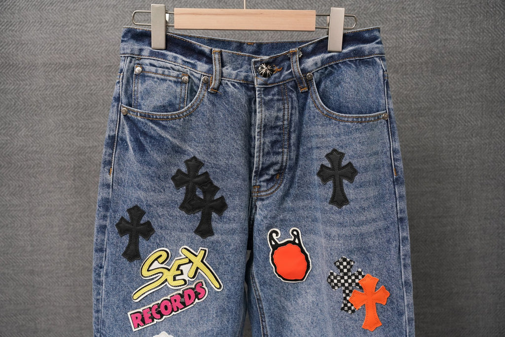 Light blue denim pants with front patches including Sex Records and red flame