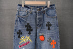 Light blue denim pants with front patches including Sex Records and red flame
