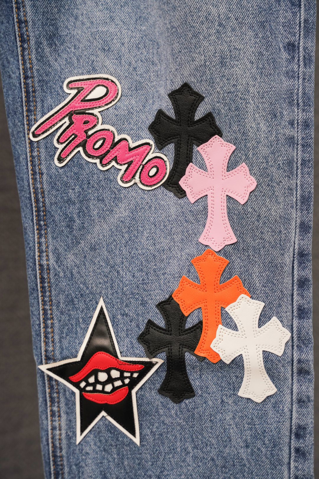 Light blue denim pants with Promo logo and multicolor cross patches