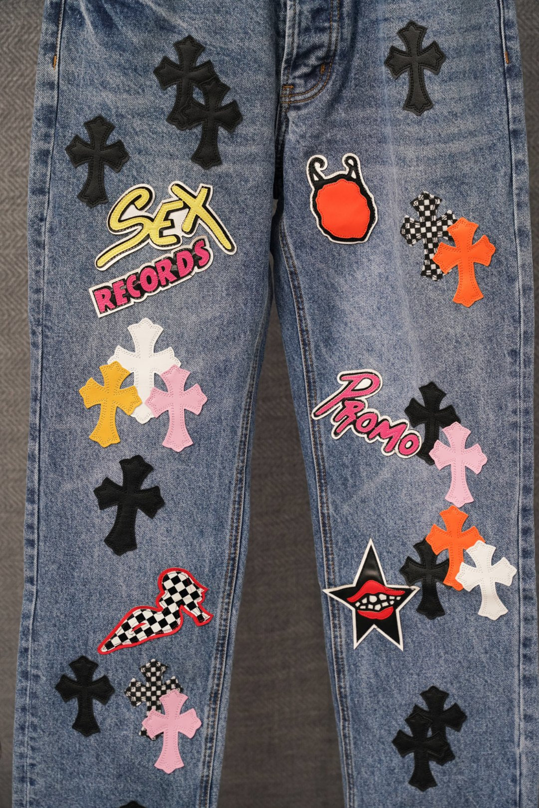 Light blue denim pants with multicolor patches featuring Sex Records and Promo