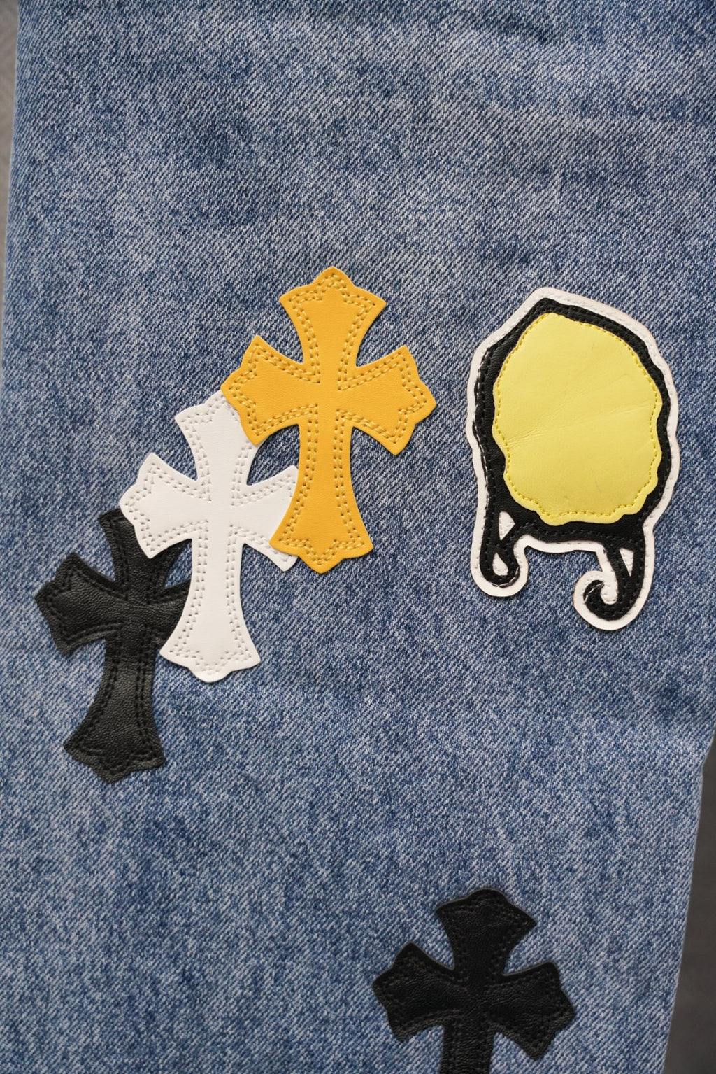 Chrome pants, light blue denim with large cross and crown-style patches