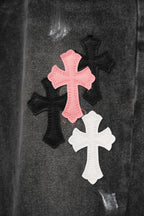 Close-up of dark denim with pink and white cross appliques on fabric