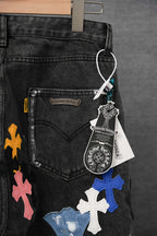 Dark denim jeans with a cross patch graphic and stitched pocket detail, hanging tag