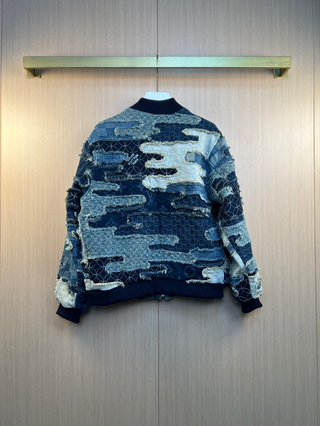 Louis Vuitton patchwork denim jacket on hanger with zip front and frayed edges