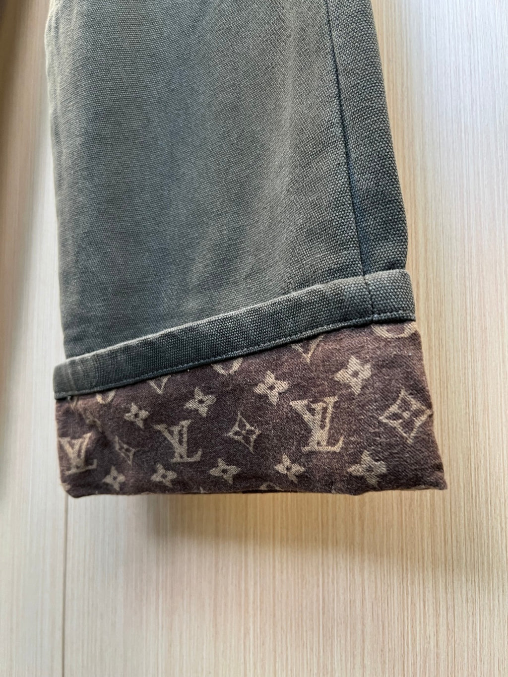 Pant cuff with dark fabric and Louis Vuitton monogram trim at the hem