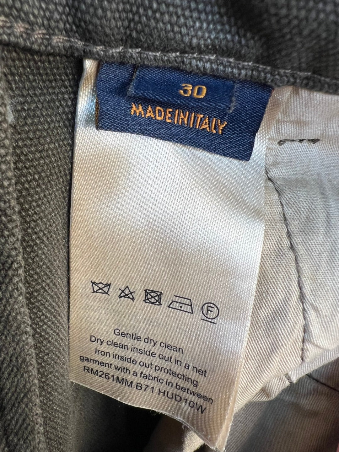 Inside care label on pants waistband, showing Made in Taiwan and washing icons