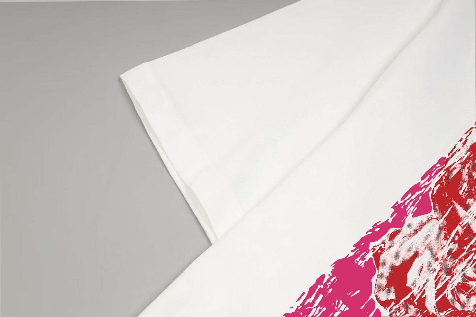 White T-shirt fabric fold with red/pink graphic edge visible