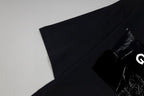 Black T-shirt folded, sleeve and chest graphic corner visible