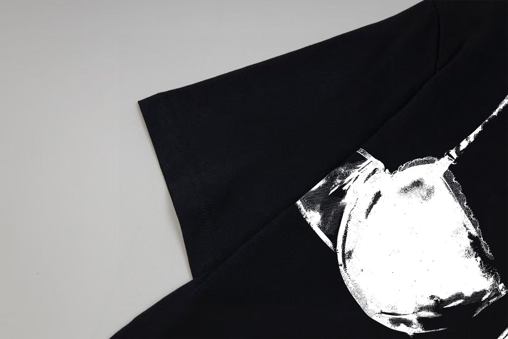 Black T-shirt sleeve and chest detail with white bust-print graphic