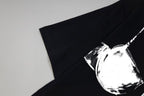 Black T-shirt sleeve and chest detail with white bust-print graphic