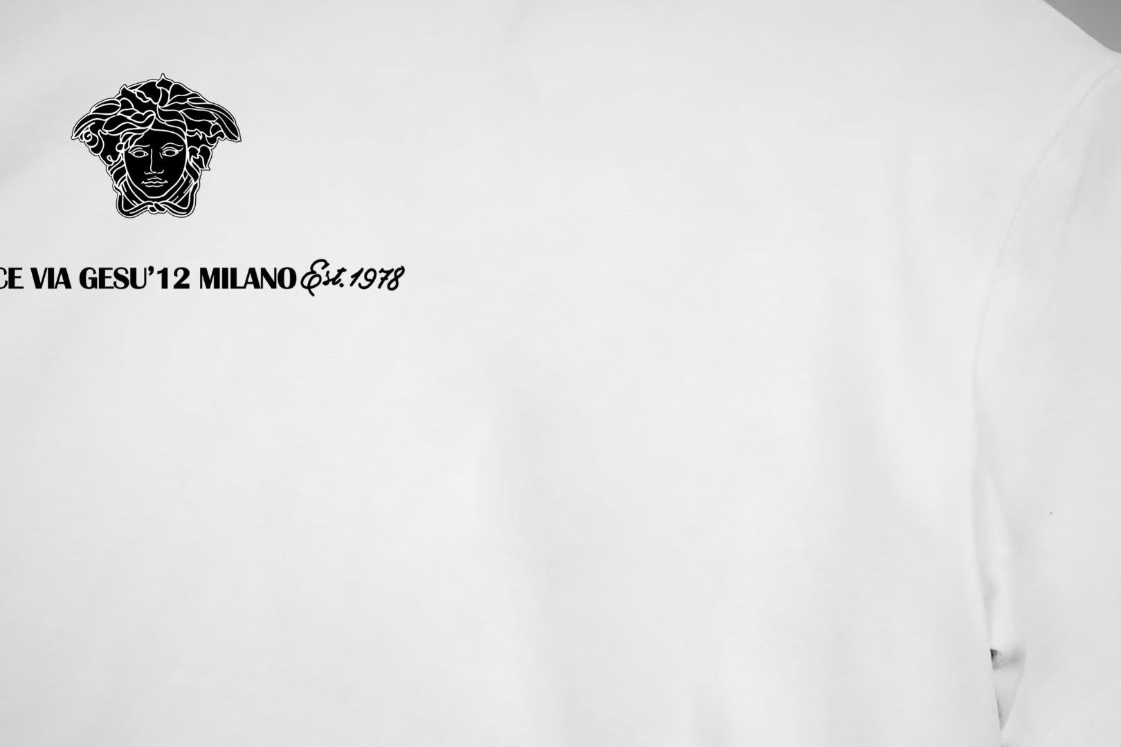 White T-shirt chest close-up with black baroque head graphic and text