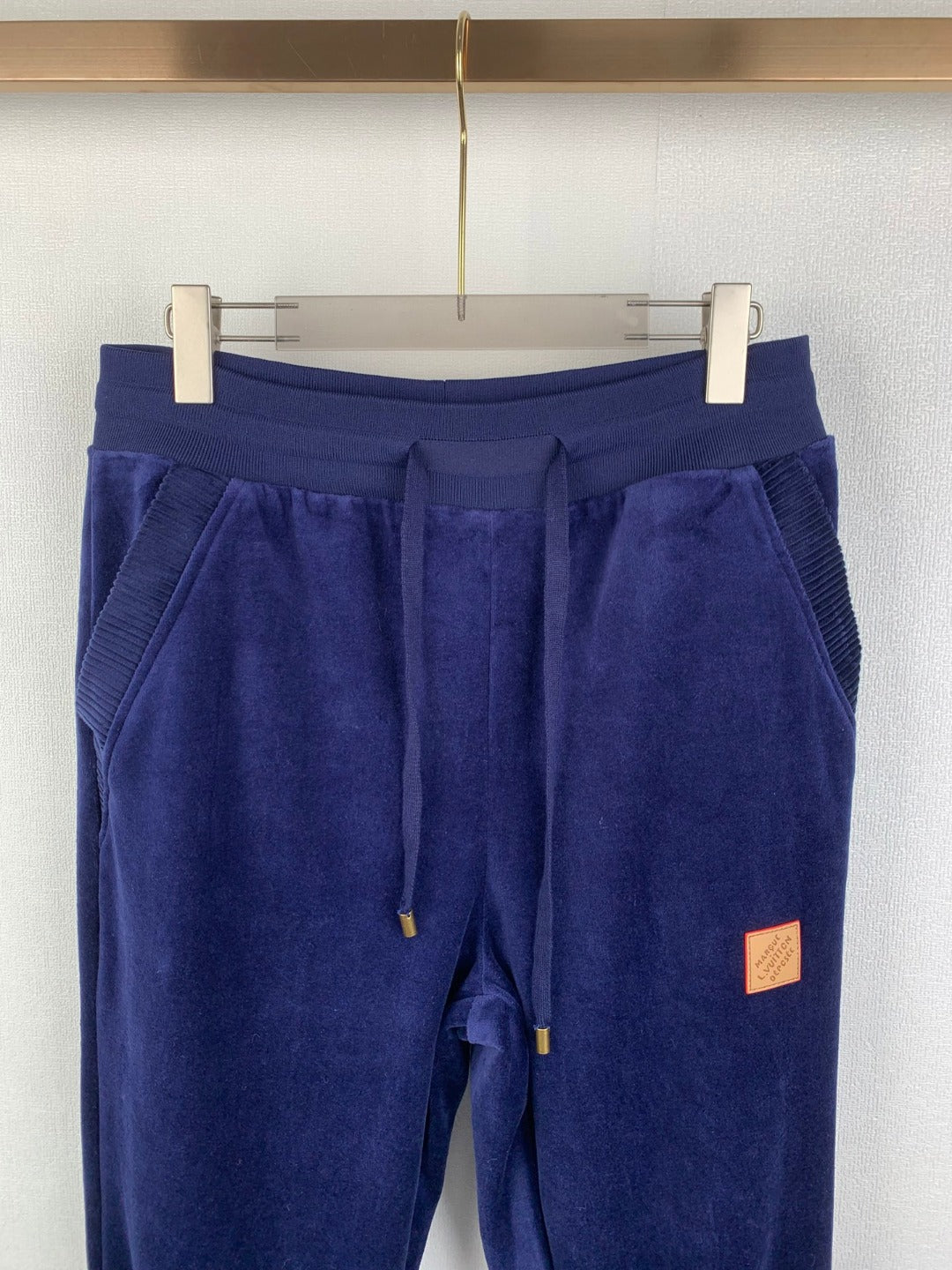 Dark blue sweatpants with drawstring, patch label, and elastic cuffs